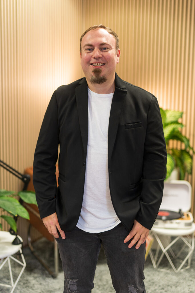 Porträt von Hochzeits DJ Hannes von der Doojayschmiede vor Holzhintergrund